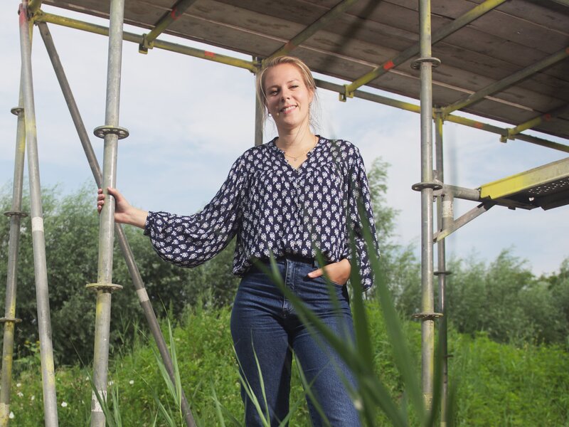 Annika van Wensveen staat op een bouwplaats tussen de steigers